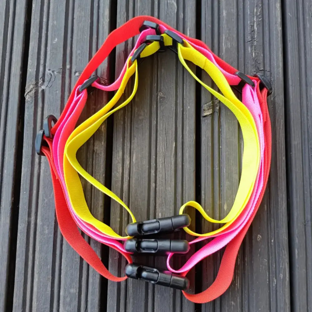 Värikkäät neopreeniset extension waistbelt- ja safety strap -vyöt punaisena, pinkkinä ja keltaisena mustilla muovilukoilla