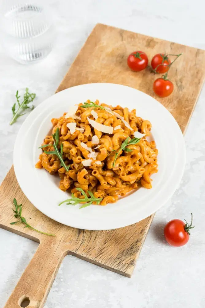 Vibrantti oranssi mac and cheese -ruoka white keraamisessa kulhossa arugulan ja parmesaanin kera food force viikon ruokapakkaus 21 ateriaa