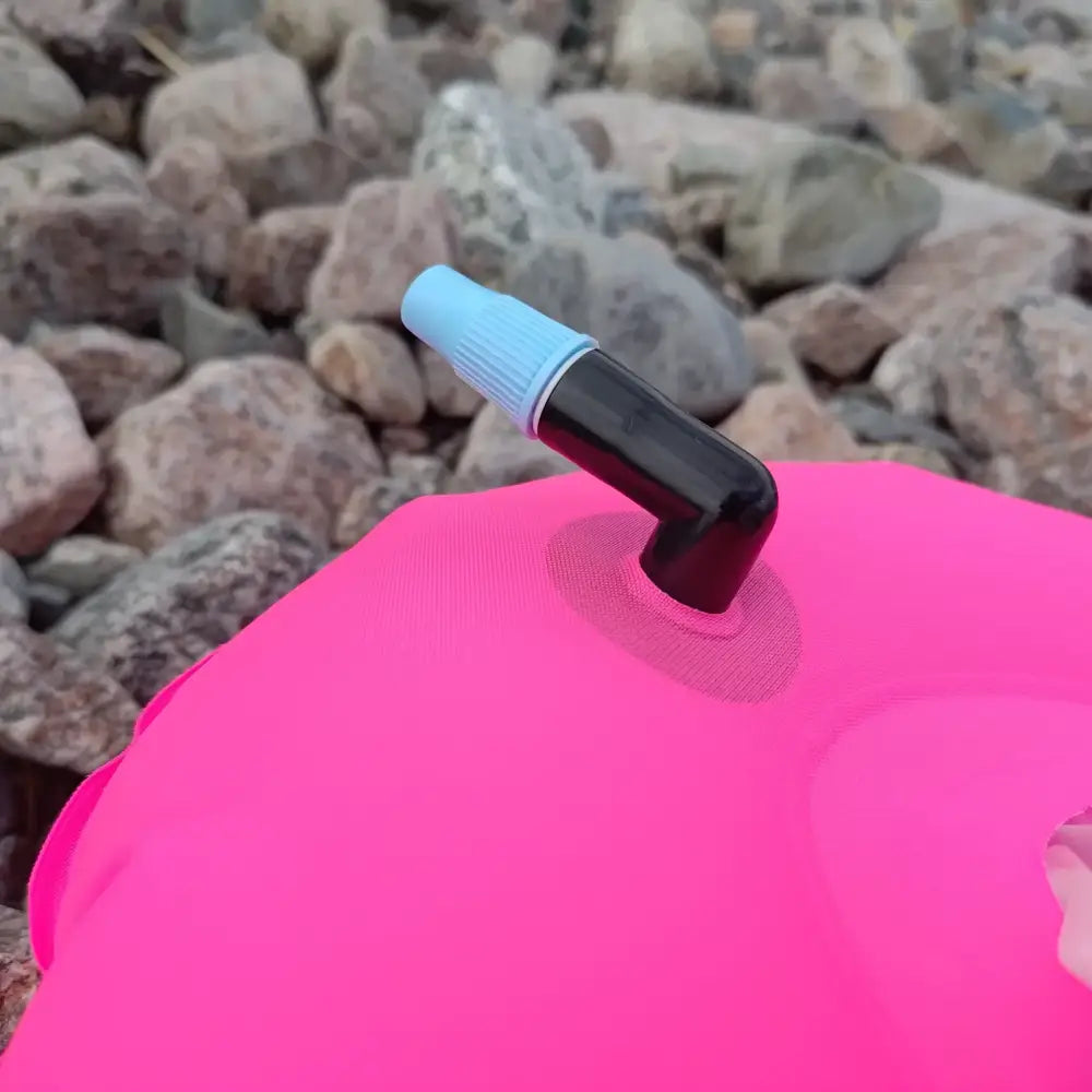 Kirkkaan pinkki grab bag donut buoy -ilmatäytteinen vesipussi mustalla ja vaaleansinisellä venttiilillä