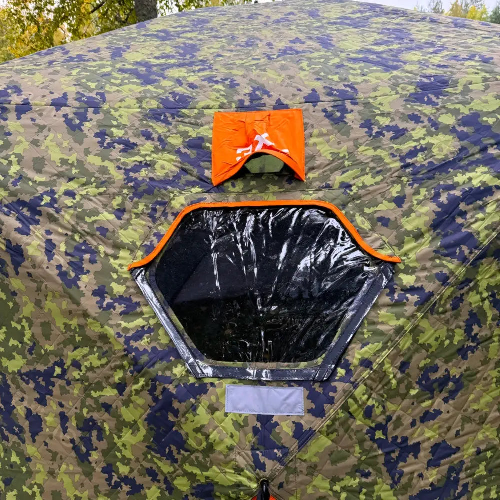 Camouflage-kuvioitu metsästysteltta haghus bushman 2xl jossa kuusikulmainen ikkuna ja oranssi läppä