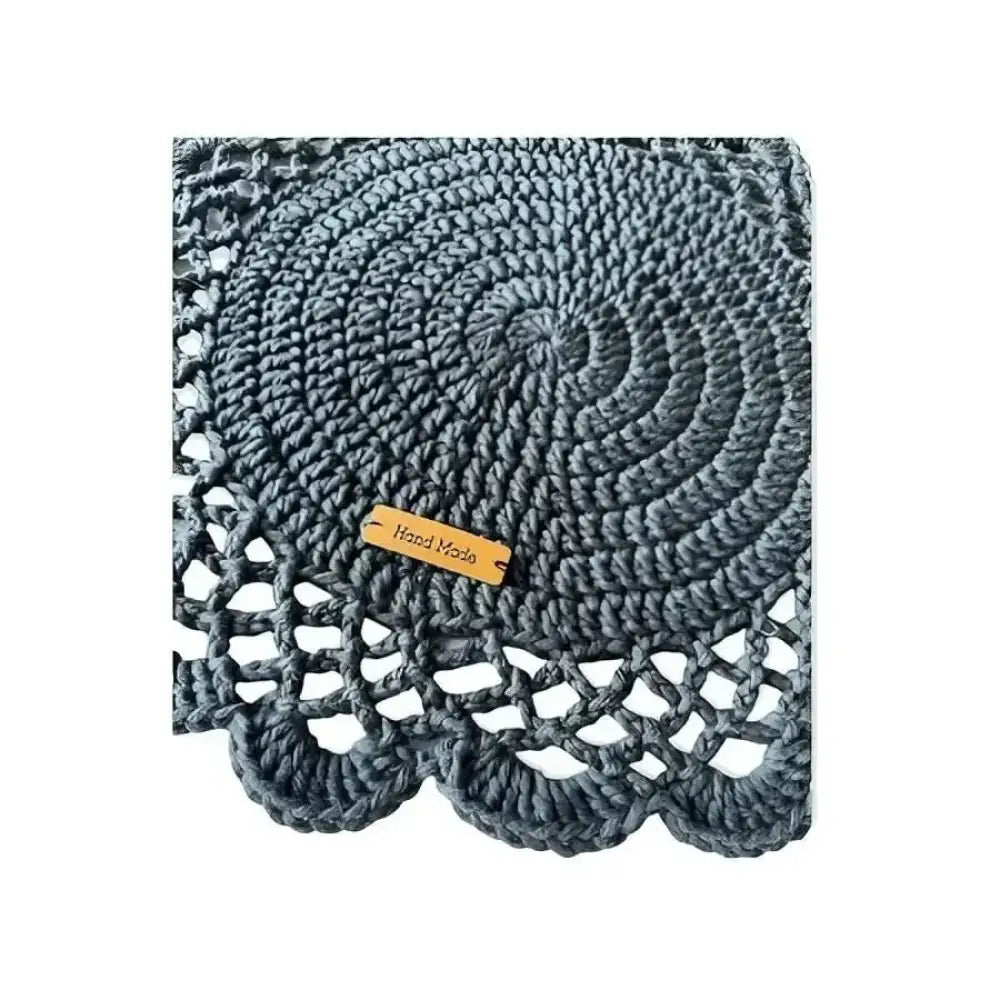 Gray crocheted kattausliina doily with spiral pattern scalloped edge and wooden hand made tag