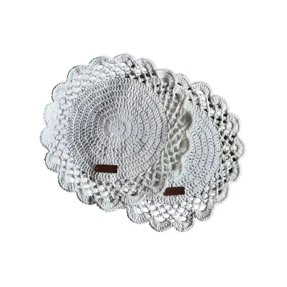Valkoinen koota crochet -pitsiliina yksityiskohtaisilla kuvioilla ja aaltoilevilla reunoilla pöydän päällysteeksi