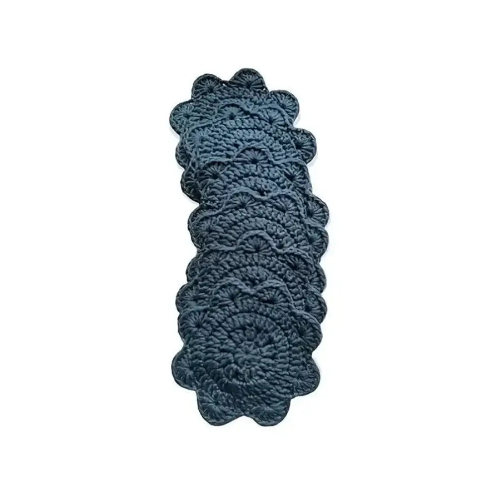 Dark blue crocheted lasinalunen coaster with scalloped edges and intricate textured pattern made of yarn