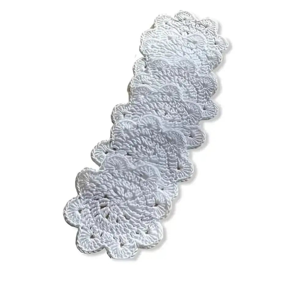 Delicate white crocheted lasinalunen pipari doily with scalloped edge and intricate floral pattern