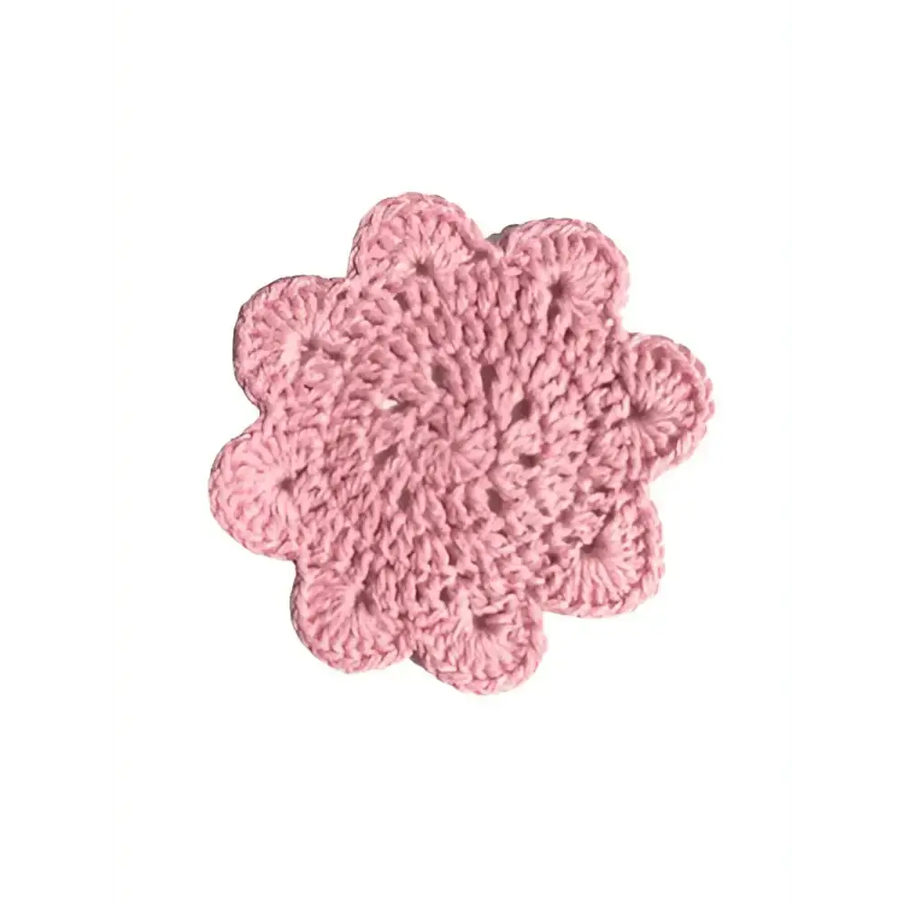 Delicate pink crocheted flower-shaped coaster with textured scalloped edge named lasinalunen pipari
