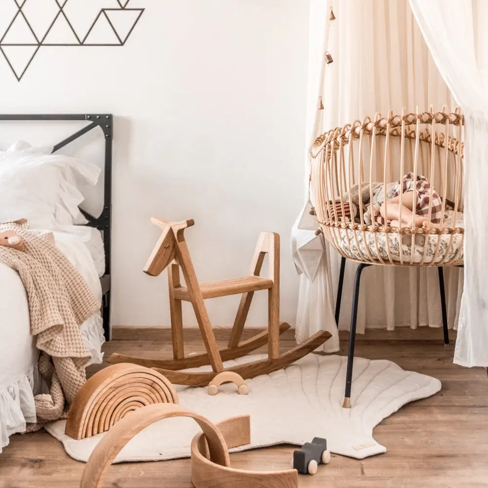 Woven rattan roikkuva kehto mustilla metallijaloilla ja kuvioidulla tyynyllä tuotteessa lillagunga reindeer