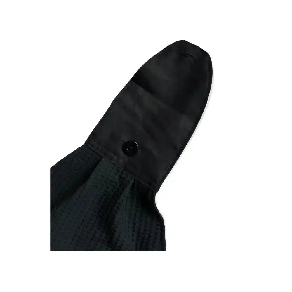 Black näppipyyhe with a waffle-textured fabric sleeve and smooth black button closure for practical use