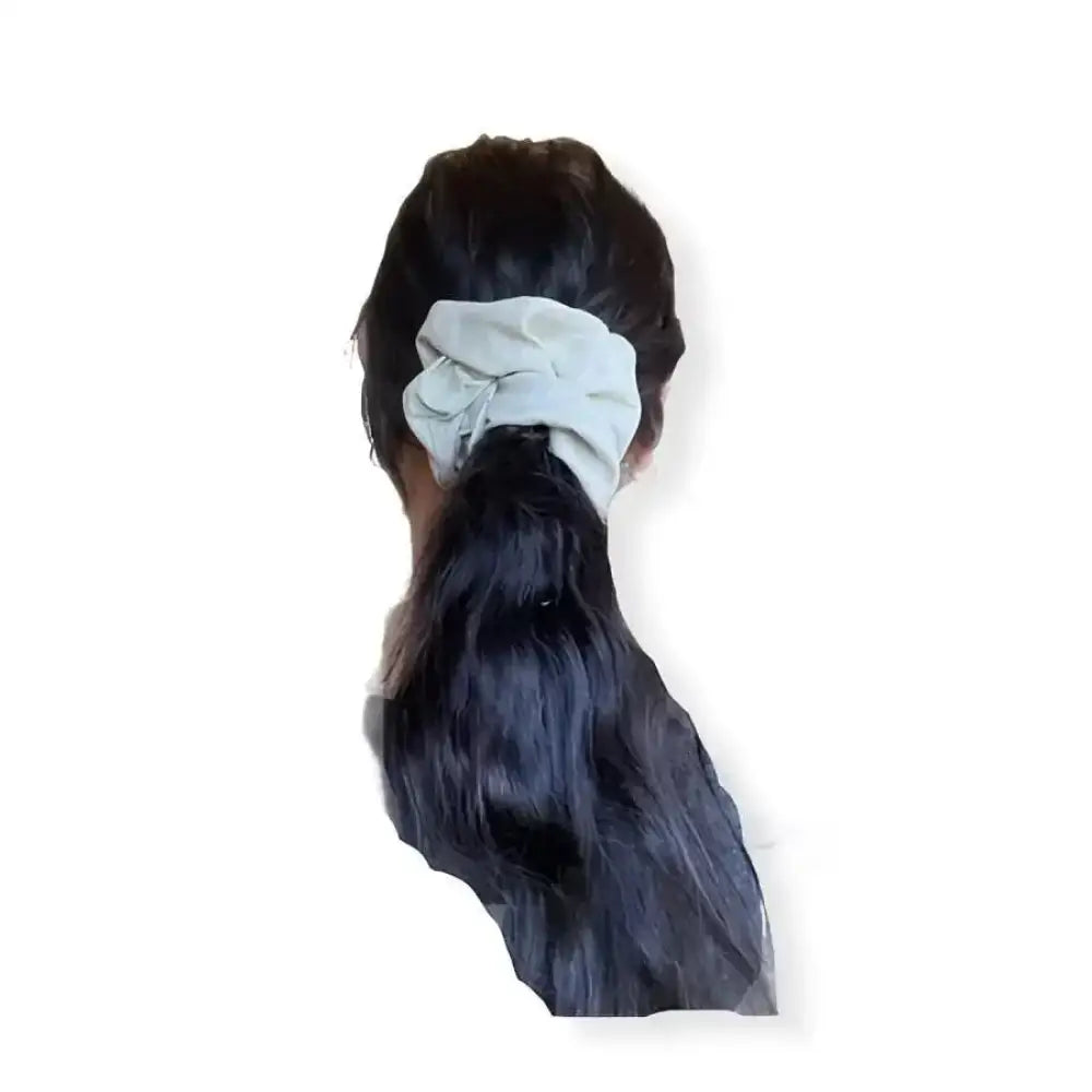 Vaaleanharmaa pellava scrunchie kiinnittää tumman poninhännän muodikkaasti ja käytännöllisesti