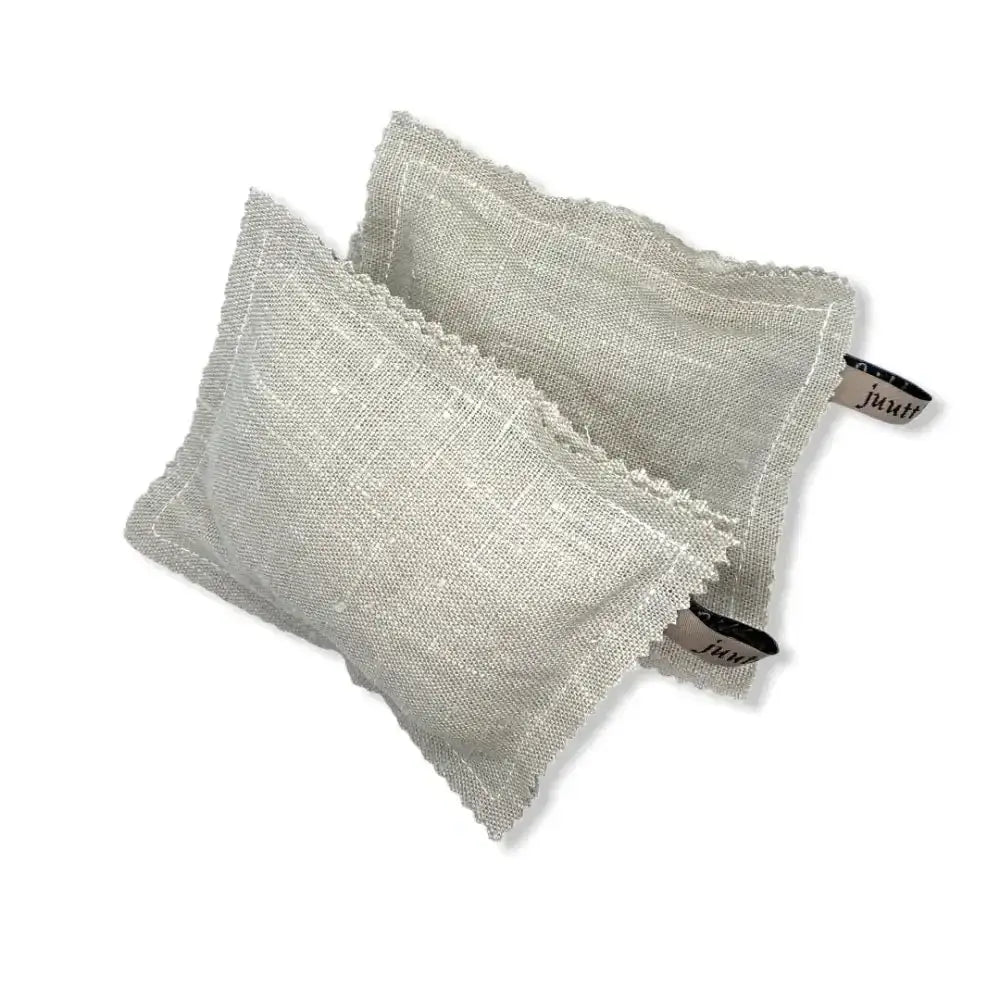 Kaksi vaaleanharmaata pellavapintaisia pesusieni pellava -sachet-pussia jossa rispaantuneet reunat ja mustavalkoiset merkkiliput