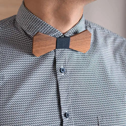 A sleek light brown wooden bow tie with a dark gray fabric center from puurusetti pähkinäpuu sininen collection