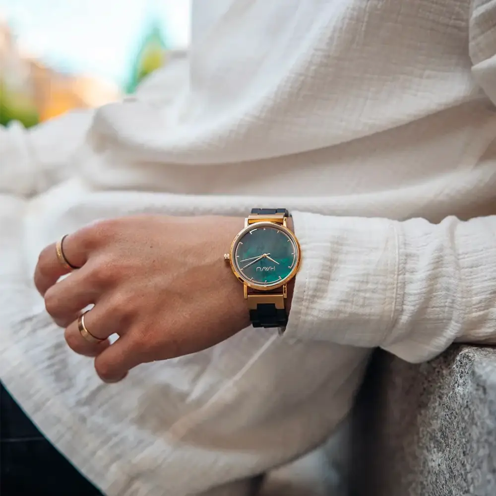 A sleek gold-toned wooden watch revontuli eebenpuu 40mm with gradient teal dial and black leather strap enakkokauppa