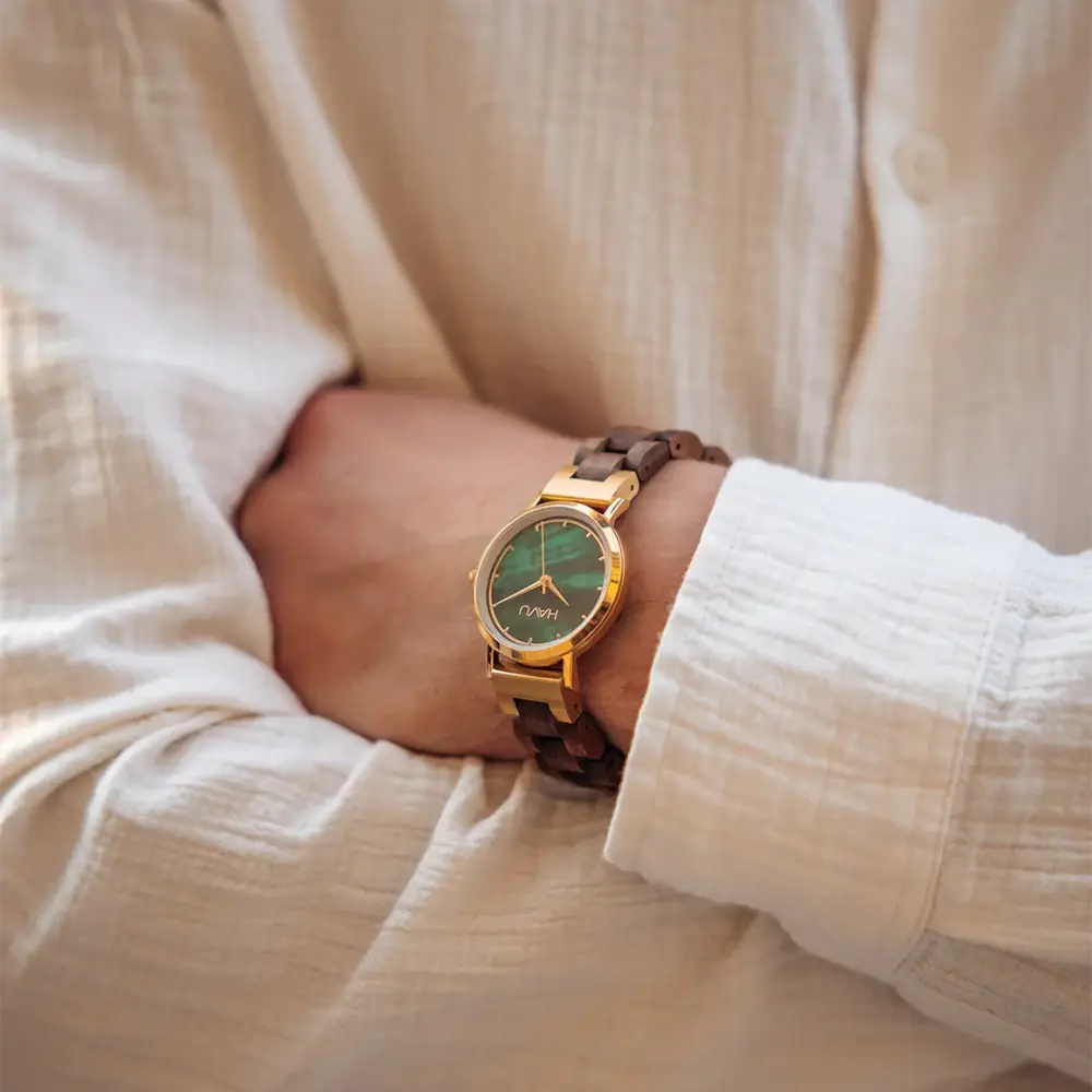 A delicate wooden watch revontuli pähkinäpuu with gold-tone case dark brown polished wood links and emerald green dial