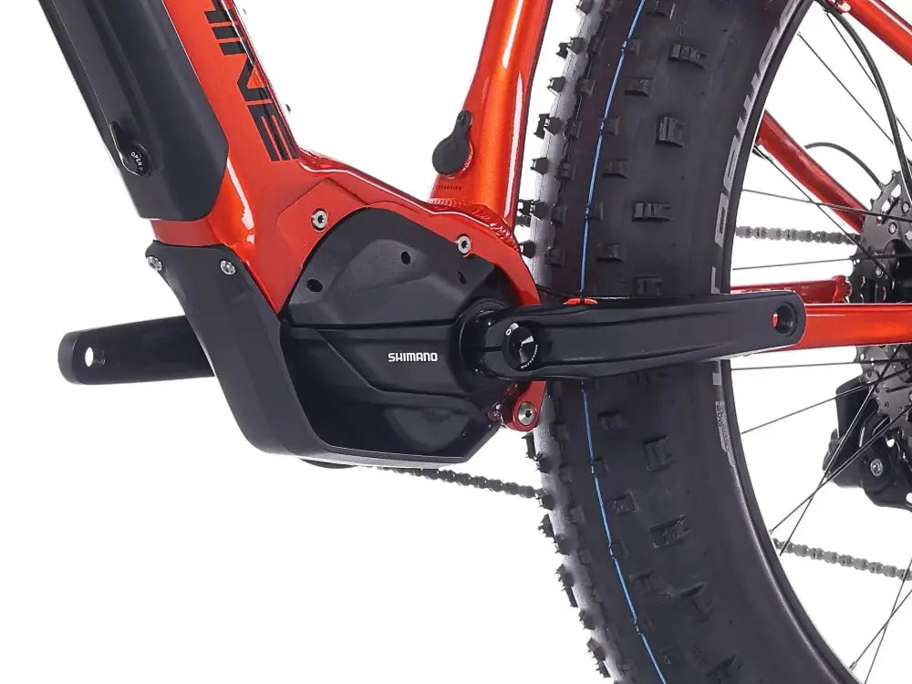 Vibrantti oranssi rock machine vyöry e90 sähköpyörä mustalla shimano moottorin kotelolla ja paksuilla maastorenkailla