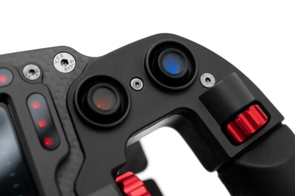 Black carbon fiber simagic FX Pro formula steering wheel with red accent buttons and blue-lit dials