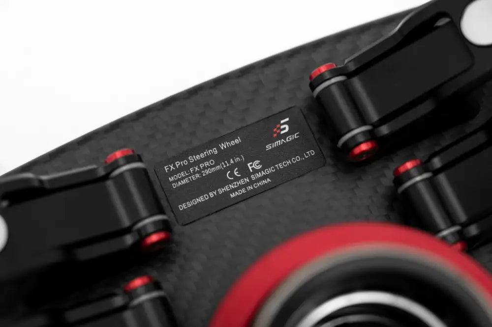 Black carbon fiber Simagic FX Pro formula steering wheel with red-accented metallic components and sleek design