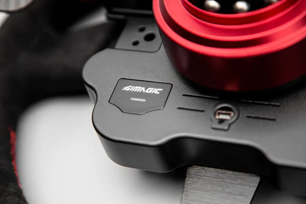Black simagic gt1 rounded steering wheel controller with red circular detail and usb port visible on back side