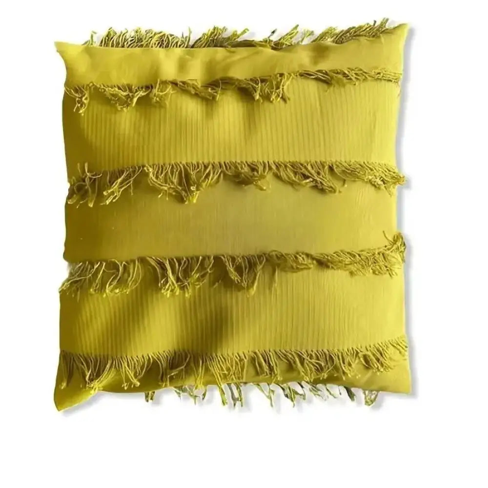 Tyynynpäällinen hapsu on neliönmuotoinen okranvärinen tyynynpäällinen kolmella vaakasuoralla teksturoidulla kankaalla ja rispaantuneilla reunoilla