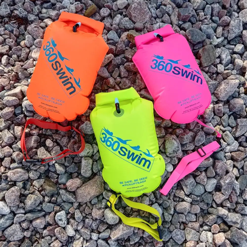 Kolme kirkkaanväristä 360swim ultra drybag buoy -ilmatäytteistä kelluntalaitetta tarrakiinnityksin