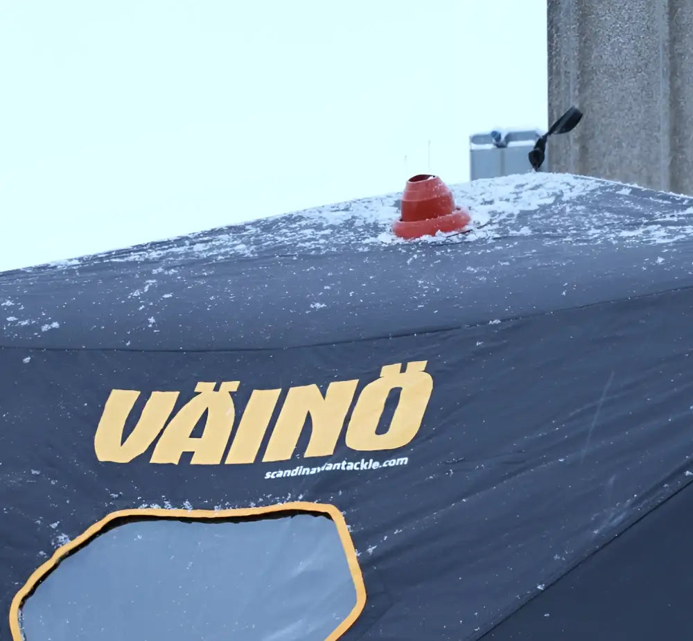 Red conical vent on top of dark blue väinö branded thermally insulated pilkkiteltta tent