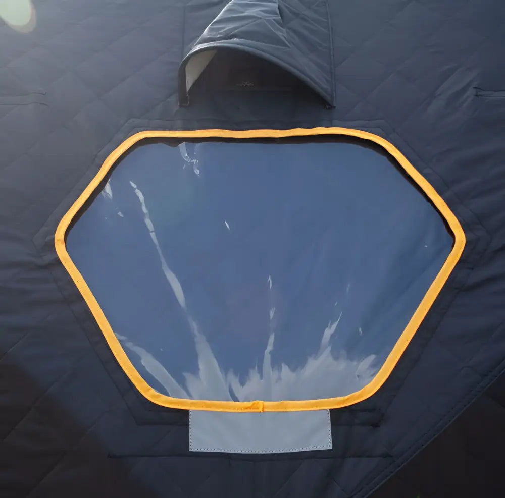 Dark blue hexagonal window with bright yellow trim and clear panel on väinö bunker thermal extreme xxxl pilkkiteltta