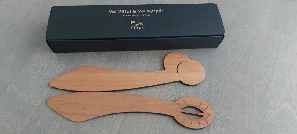 Kaksi vaaleanruskeaa puista voiveistä, joista toisessa on pyöreä ja toisessa soikea kaiverrettu kahva, voi vittu voi kyrpä lahjasetti