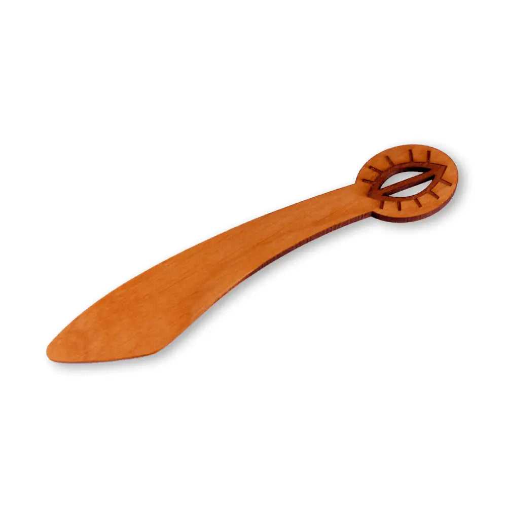 A smooth light brown wooden spoon with a rounded handle and intricate carved design from voi vittu voiveitsi collection