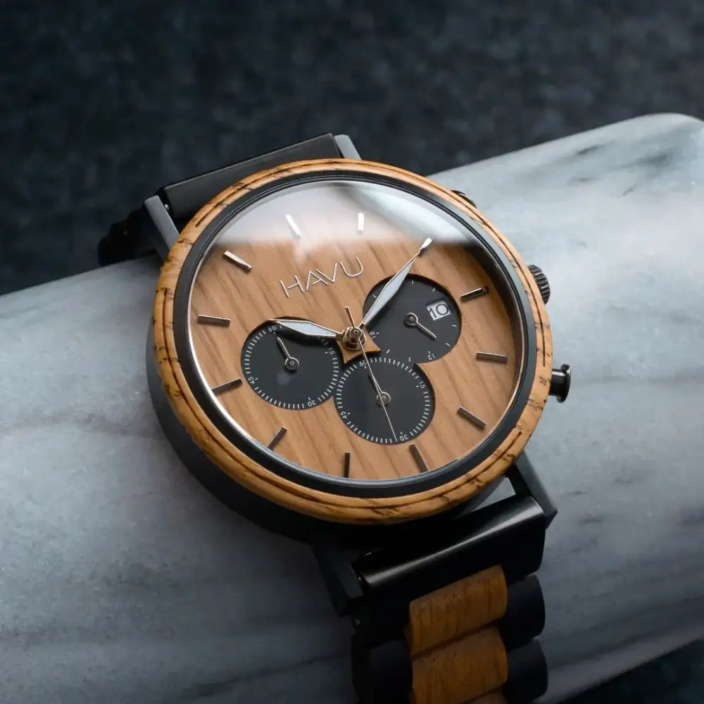 A sleek Vuori 44mm havu chronograph watch with natural wood grain dial black accents and wooden strap