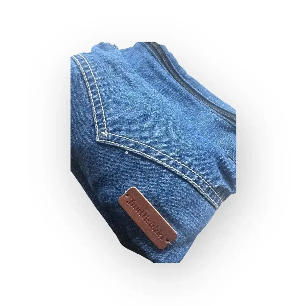 Vyölaukku farkku sinisestä denimmateriaalista valkoisilla saumoilla ja ruskealla nahkalaatikolla