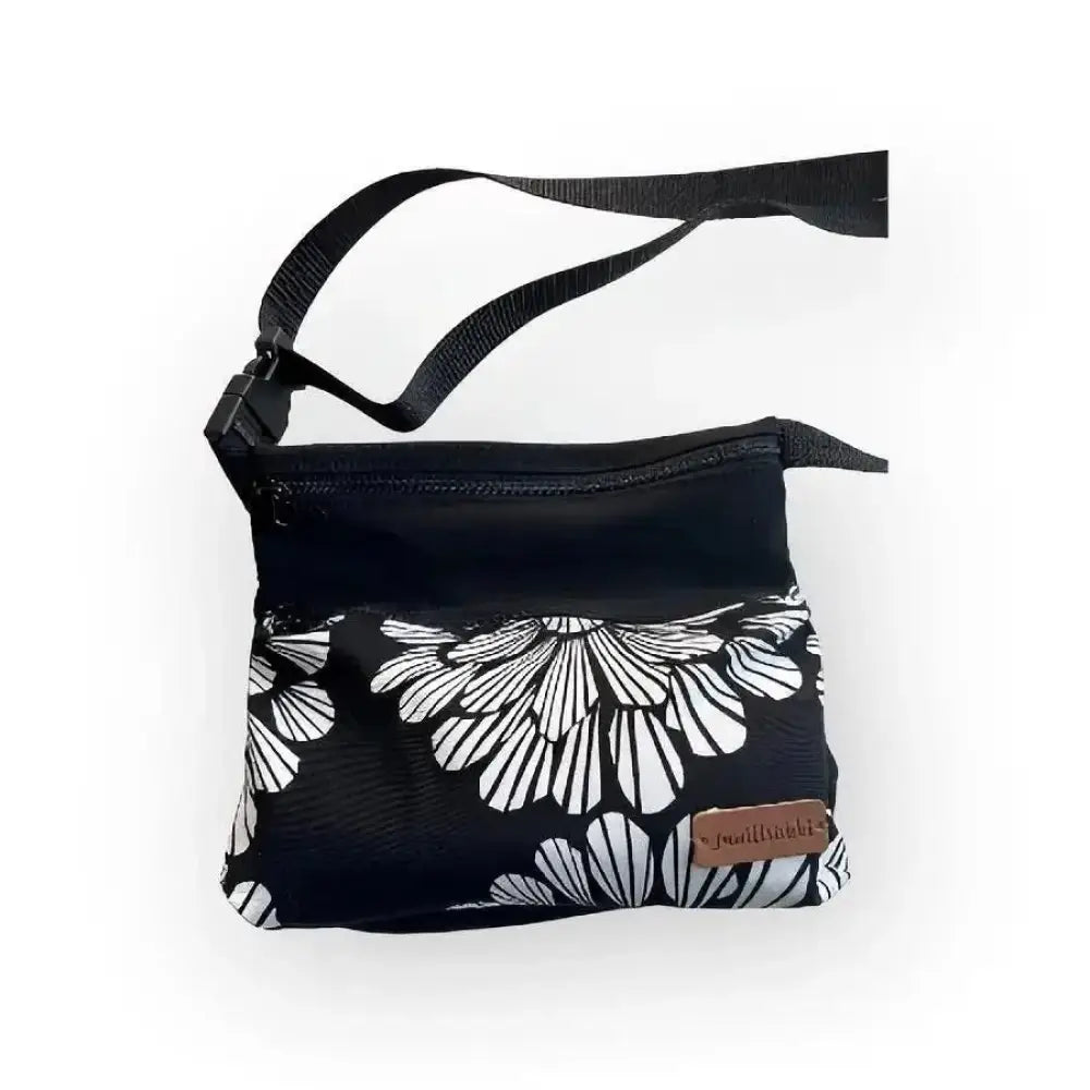 Vyölaukku Mustakukka musta crossbody-laukku valkoisella kukkakuviolla ja säädettävällä hihnalla