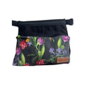 Mustapohjainen vyölaukku niitty jossa kirkkaat tulppaanit ja violetit kukat sekä ruskea nahkainen brändilaatta